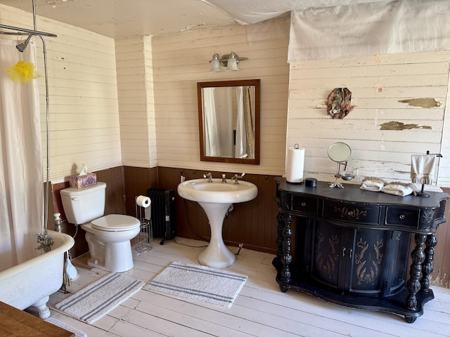 17 Boynton St, Eastport, ME 04631 - full bath with wood walls, radiator, a freestanding bath, toilet, and wood finished floors