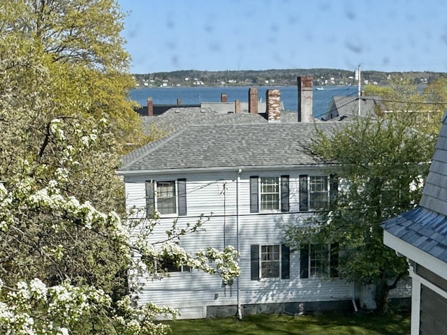 17 Boynton St, Eastport, ME 04631 - view of side of property featuring a water view, a chimney, and a shingled roof