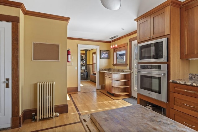 47 Atlantic Ave, Boothbay Harbor, ME 04538 - kitchen featuring radiator heating unit, light wood-style floors, stainless steel appliances, and brown cabinets