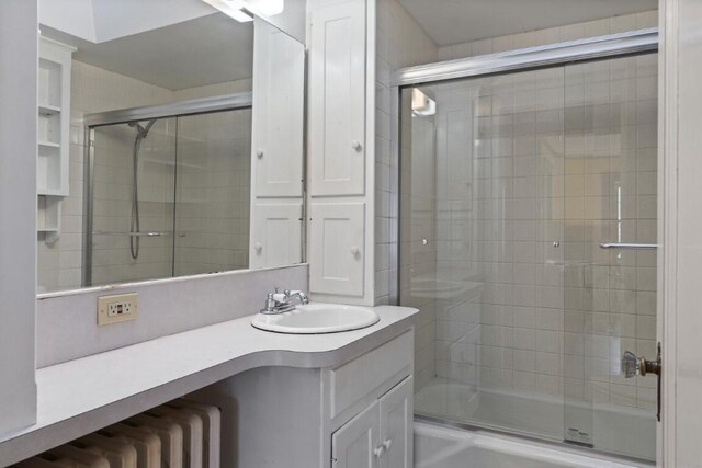 47 Atlantic Ave, Boothbay Harbor, ME 04538 - bathroom featuring vanity, radiator, and enclosed tub / shower combo