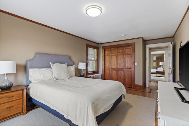 47 Atlantic Ave, Boothbay Harbor, ME 04538 - bedroom featuring ornamental molding, radiator heating unit, light wood finished floors, and a closet