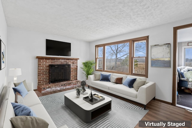 living room featuring a brick fireplace, a textured ceiling, baseboards, and wood finished floors