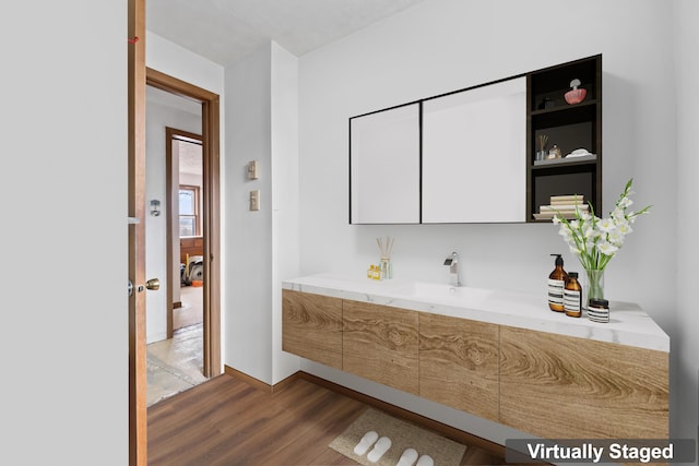 bathroom with vanity, baseboards, and wood finished floors