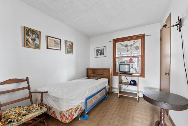 bedroom with a textured ceiling and a baseboard radiator
