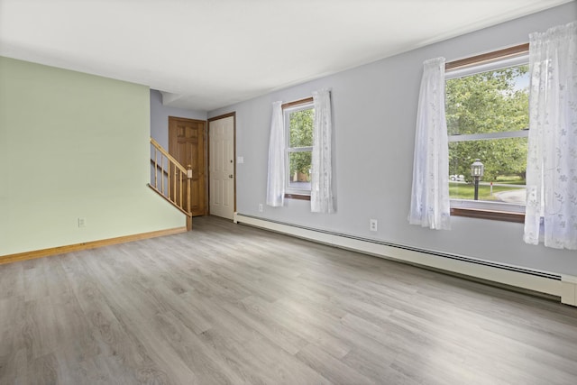 84 Old Carriage Rd Unit 84, Auburn, ME 04210 - empty room featuring a baseboard heating unit, stairs, and wood finished floors