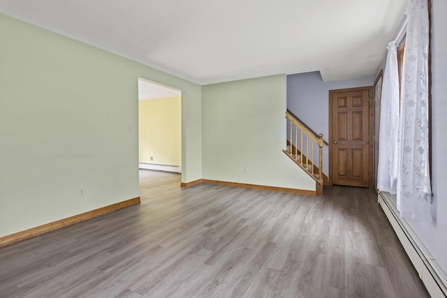 84 Old Carriage Rd Unit 84, Auburn, ME 04210 - unfurnished living room featuring baseboard heating, a baseboard radiator, wood finished floors, and stairway