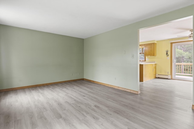84 Old Carriage Rd Unit 84, Auburn, ME 04210 - unfurnished living room with light wood-style flooring, a baseboard radiator, and ceiling fan