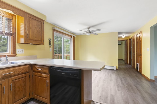 84 Old Carriage Rd Unit 84, Auburn, ME 04210 - kitchen featuring dishwasher, baseboard heating, light countertops, light wood-type flooring, and a peninsula