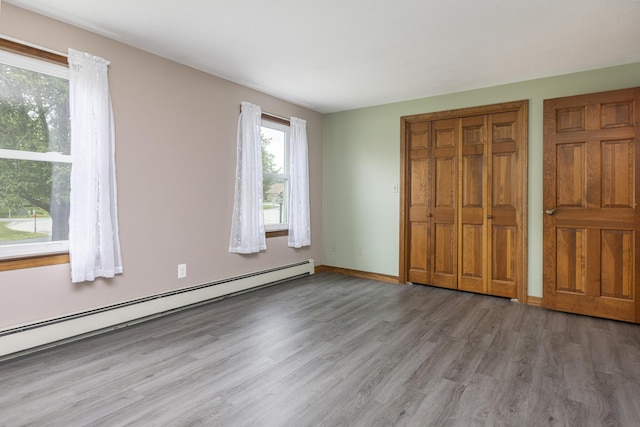 84 Old Carriage Rd Unit 84, Auburn, ME 04210 - unfurnished bedroom with a baseboard radiator, wood finished floors, and a closet