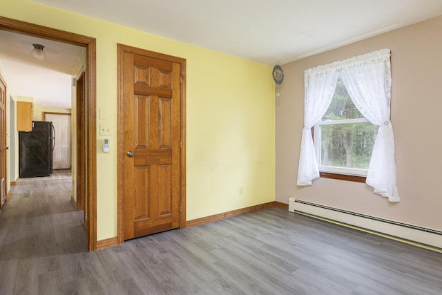 84 Old Carriage Rd Unit 84, Auburn, ME 04210 - empty room with a baseboard heating unit and wood finished floors