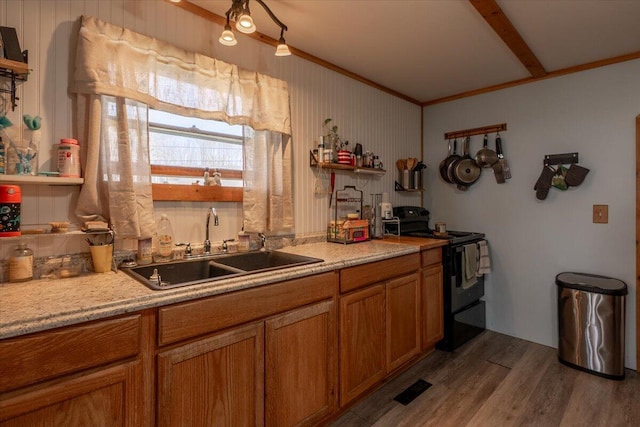 433 N Union Rd, Union, ME 04862 - kitchen with ornamental molding, wood finished floors, black electric range oven, brown cabinets, and a sink