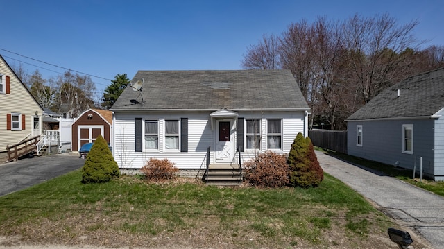 867 Minot Ave, Auburn, ME 04210 - cape cod home featuring roof with shingles and a storage shed