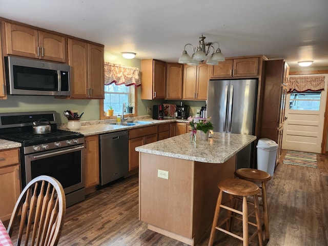 53 Village Rd, Stetson, ME 04488 - kitchen featuring appliances with stainless steel finishes, a sink, dark wood finished floors, a breakfast bar, and a kitchen island