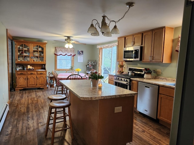 53 Village Rd, Stetson, ME 04488 - kitchen with stainless steel appliances, a breakfast bar area, healthy amount of natural light, and dark wood-style floors