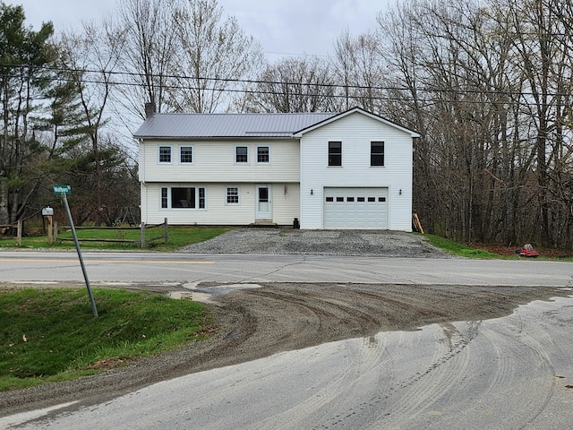53 Village Rd, Stetson, ME 04488 - view of front facade featuring an attached garage, driveway, metal roof, and a chimney
