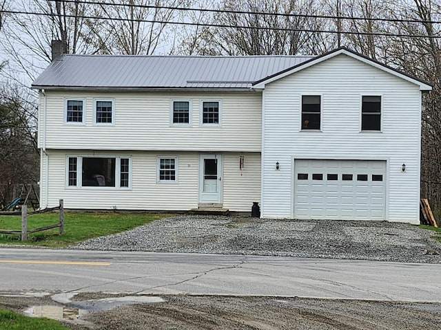53 Village Rd, Stetson, ME 04488 - view of front of property with driveway, an attached garage, entry steps, and metal roof