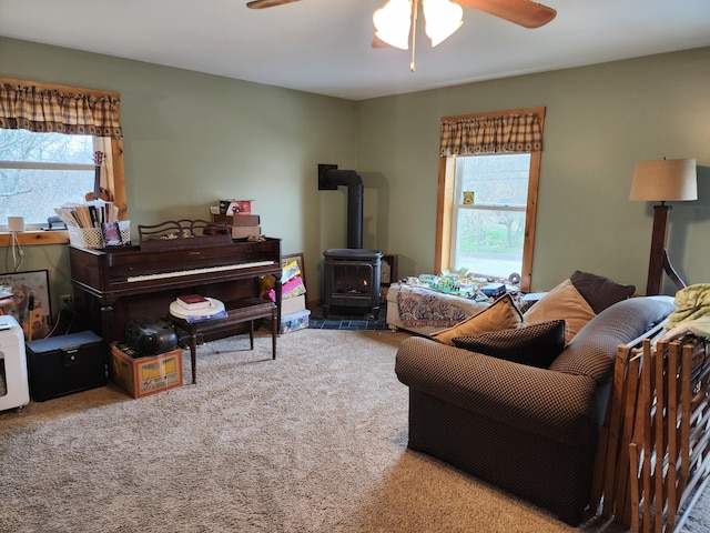 53 Village Rd, Stetson, ME 04488 - carpeted living room featuring a ceiling fan and a wood stove