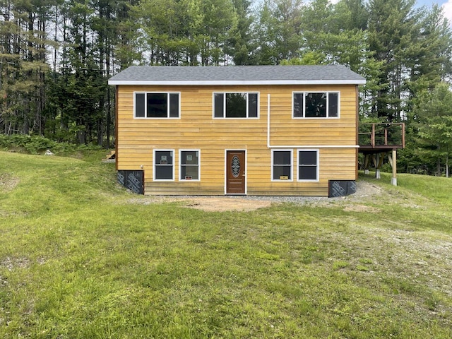 144 Redneck Rd, Starks, ME 04911 - view of front of home with a front yard, view of wooded area, a deck, and roof with shingles