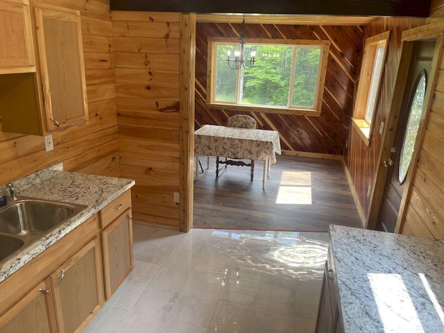 144 Redneck Rd, Starks, ME 04911 - kitchen featuring wood walls, a chandelier, light stone countertops, light wood-type flooring, and decorative light fixtures
