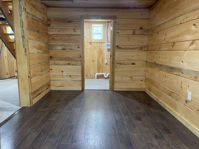 144 Redneck Rd, Starks, ME 04911 - empty room featuring dark wood-style floors, wood walls, and stairway