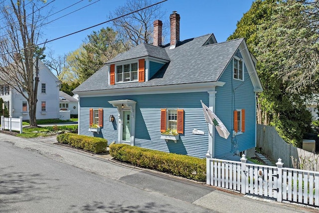 bungalow featuring roof with shingles, fence, and a chimney
