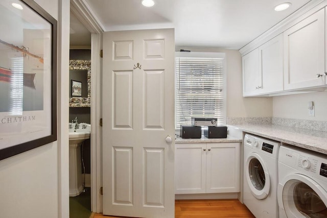 laundry area featuring recessed lighting, light wood finished floors, cabinet space, and washing machine and clothes dryer