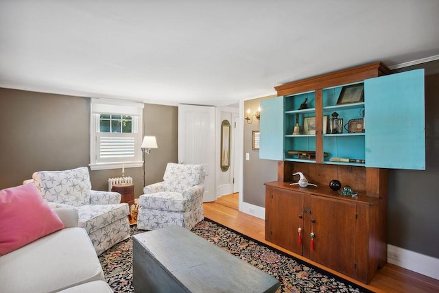 living area with baseboards and light wood finished floors