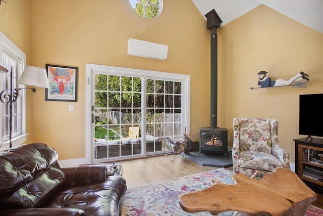 living area with high vaulted ceiling, a wood stove, a wall mounted air conditioner, and wood finished floors