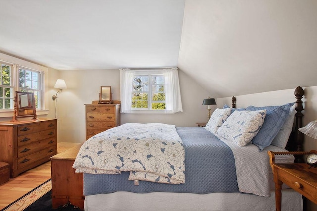 bedroom with light wood-type flooring and vaulted ceiling
