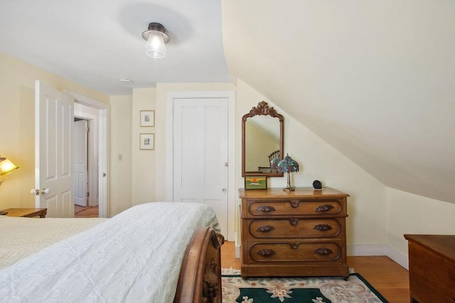 bedroom with baseboards, wood finished floors, and a closet