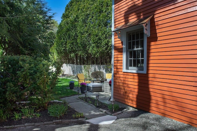 view of side of home featuring fence and a patio area