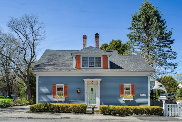 bungalow-style home featuring fence and a chimney