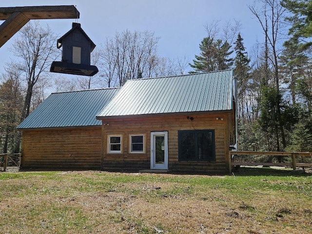 back of property featuring a lawn, fence, and metal roof