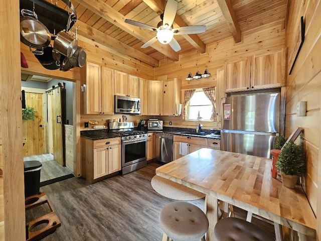 kitchen with dark countertops, appliances with stainless steel finishes, wood ceiling, and beam ceiling