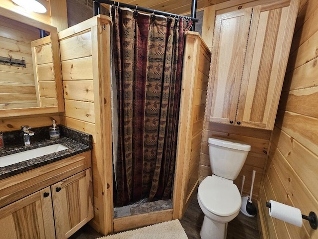 bathroom featuring toilet, a shower stall, and vanity