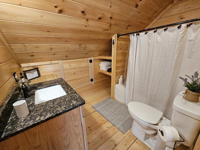 full bath with vanity, wood walls, toilet, and hardwood / wood-style floors