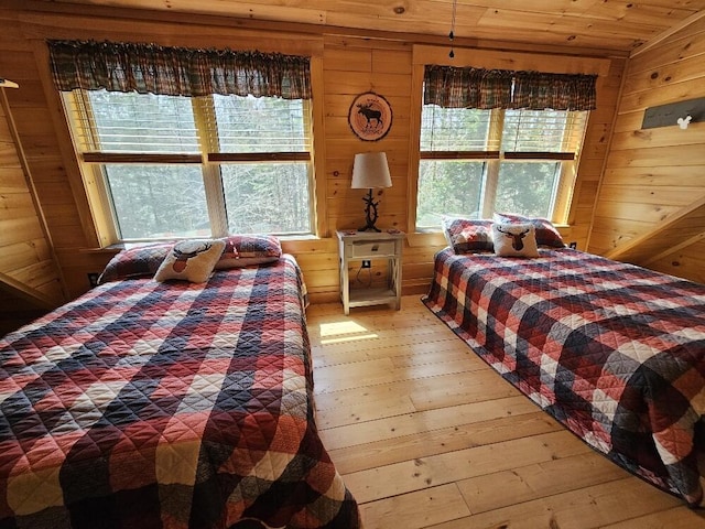 bedroom featuring wood walls, hardwood / wood-style floors, and wooden ceiling