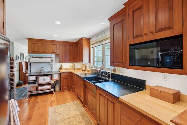 33 Smith Rd, Hallowell, ME 04347 - kitchen featuring light wood-type flooring, brown cabinetry, a sink, and black microwave