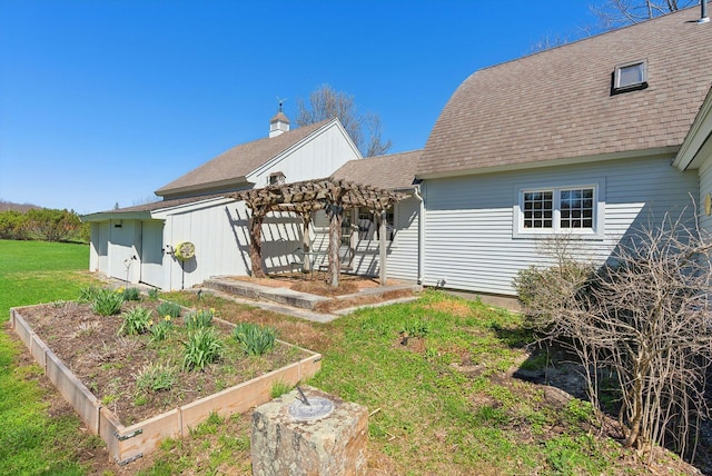 33 Smith Rd, Hallowell, ME 04347 - rear view of property featuring a pergola, a shingled roof, a vegetable garden, and a yard