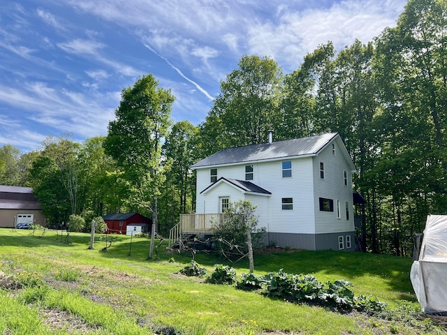 142 Palmer Rd, Thorndike, ME 04986 - view of home's exterior featuring a lawn, a deck, a metal roof, and view of wooded area