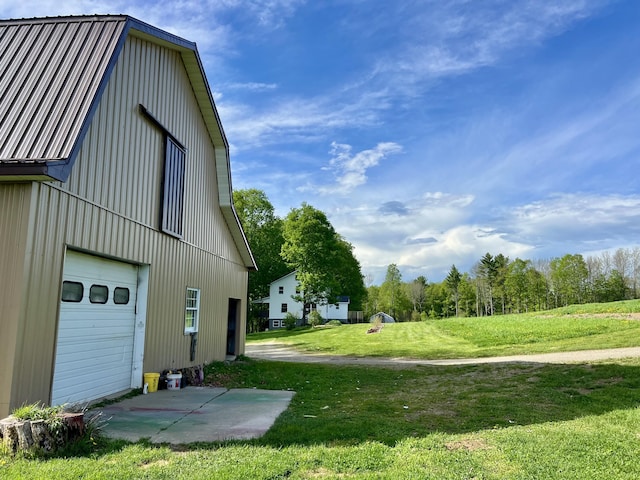 142 Palmer Rd, Thorndike, ME 04986 - view of property exterior featuring a yard, a garage, an outbuilding, and a metal roof
