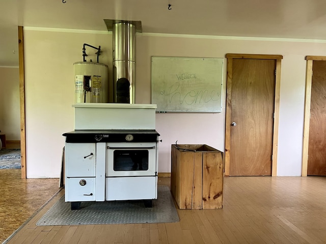 142 Palmer Rd, Thorndike, ME 04986 - kitchen featuring wood-type flooring, water heater, and ornamental molding