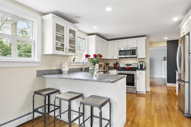13 Juniper Ln, Cape Elizabeth, ME 04107 - kitchen featuring stainless steel appliances, a peninsula, white cabinetry, light wood-style floors, and a kitchen breakfast bar