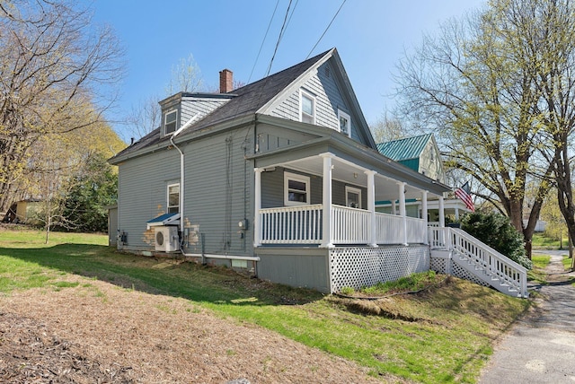view of side of property featuring stairs, covered porch, and a chimney