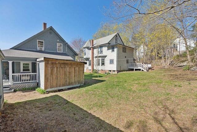 rear view of property featuring a chimney and a yard
