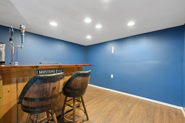 bar featuring recessed lighting, baseboards, a dry bar, and wood finished floors