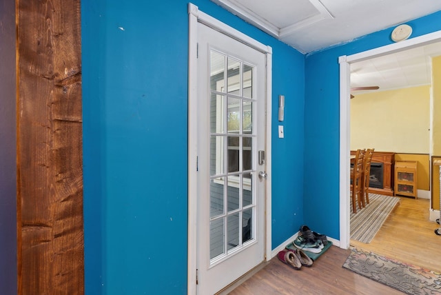doorway to outside featuring baseboards and wood finished floors