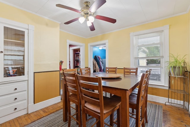 dining room with light wood-style floors, crown molding, and ceiling fan
