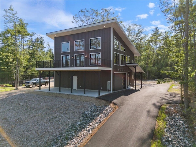 676 Sebago Rd, Sebago, ME 04029 - back of property with an attached garage, aphalt driveway, and a balcony