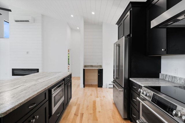 676 Sebago Rd, Sebago, ME 04029 - kitchen featuring ventilation hood, light wood finished floors, dark cabinetry, stainless steel appliances, and recessed lighting